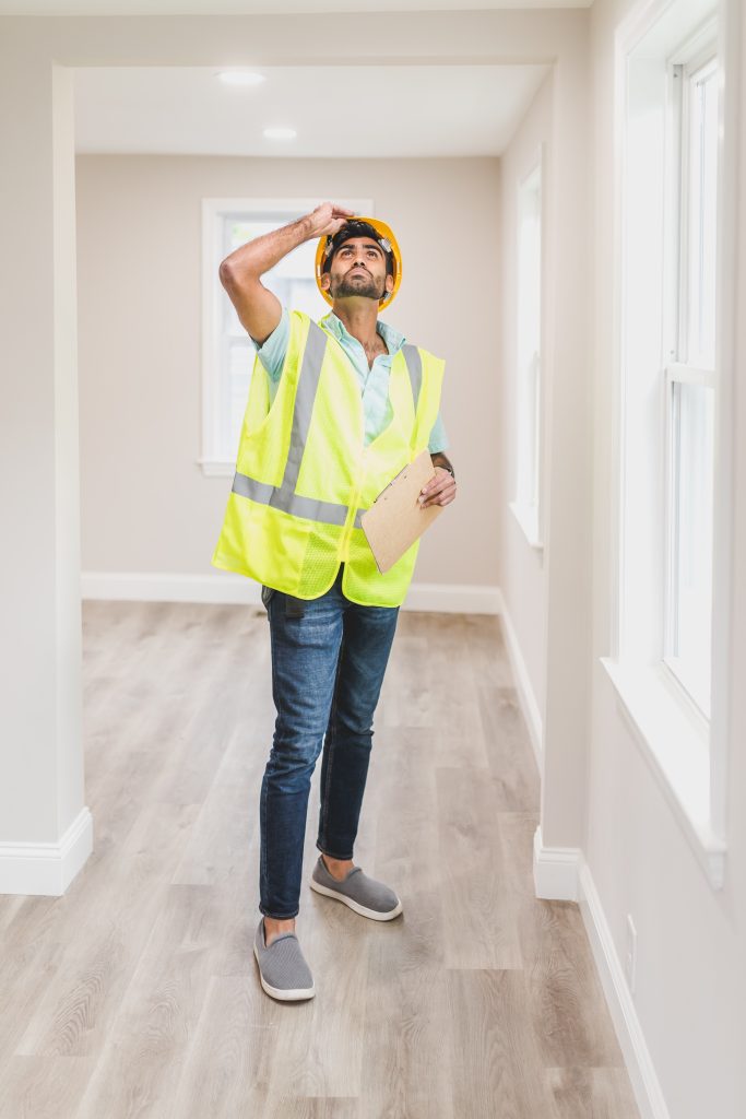 man inspecting home for needed repairs